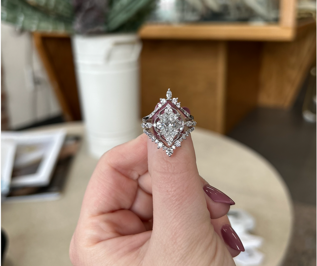 Oval diamond engagement ring with ornate white-metal setting, front view
