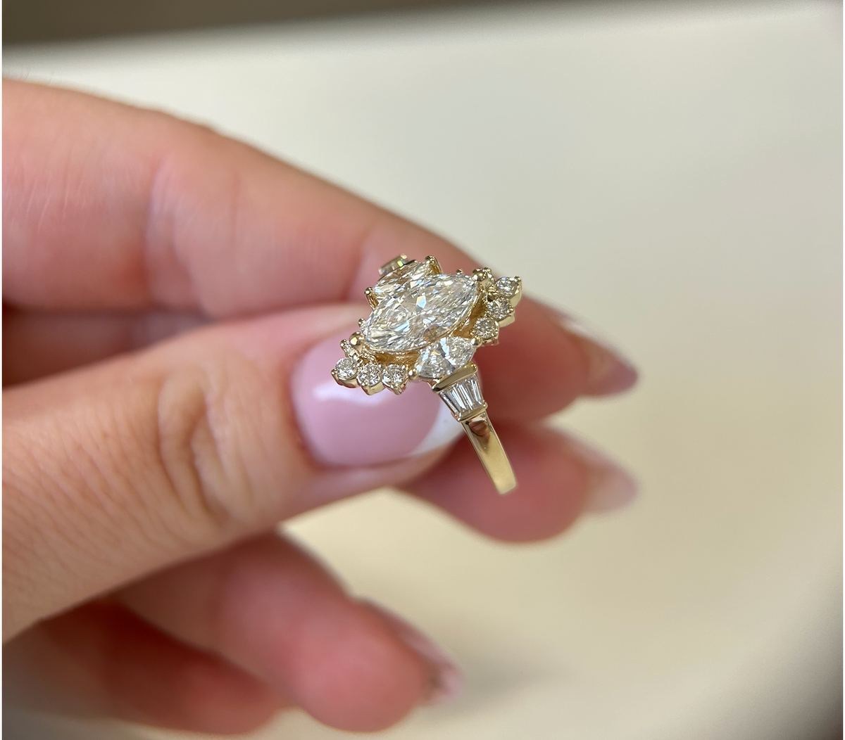 Angled view of a marquise engagement ring with diamond accents