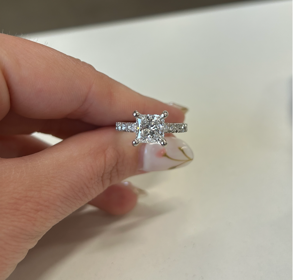 Princess-cut diamond engagement ring with a pavé white-metal band