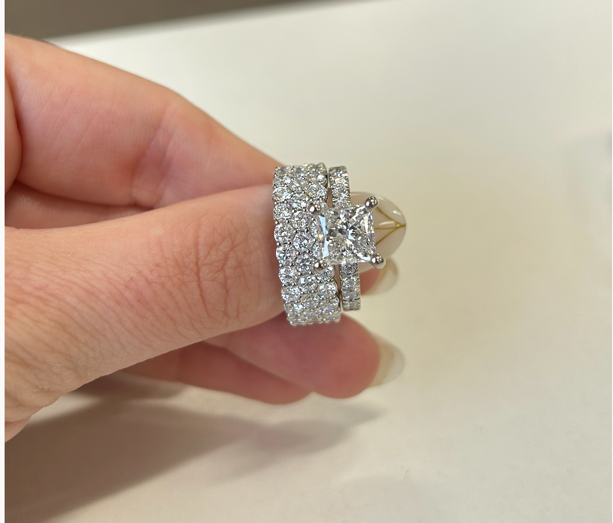 Princess-cut engagement ring paired with diamond wedding bands