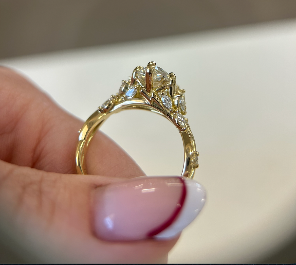 Side profile of a yellow-gold marquise engagement ring and its detailed setting
