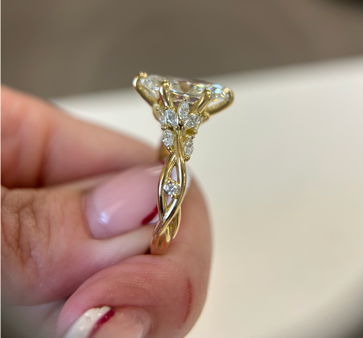 Side view of a custom marquise engagement ring with a twisted yellow-gold band