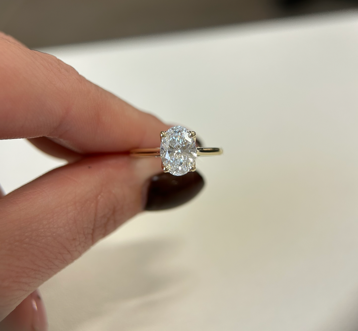 Oval diamond solitaire engagement ring in yellow gold, front view