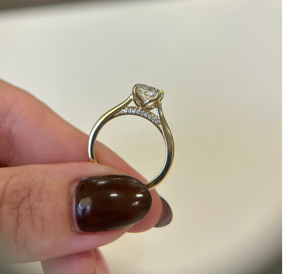 Side view of an oval solitaire engagement ring with hidden diamond details